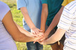 © Pixel-Shot - Children putting hands together outdoors