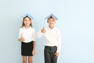 Wall Mural - Little pupils with books showing thumb-up on color background