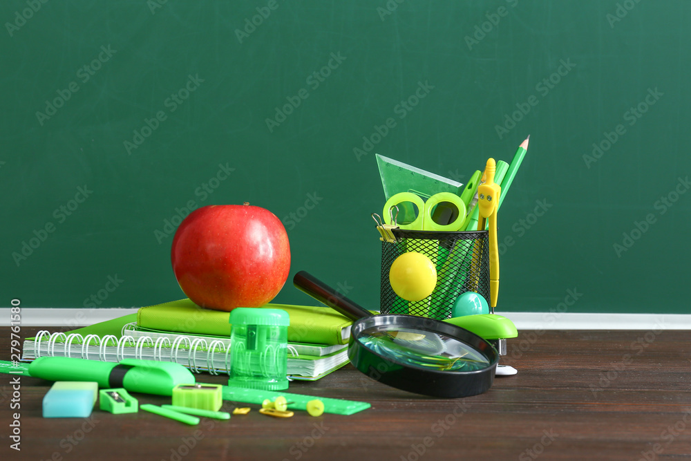 Set of school supplies on table in classroom