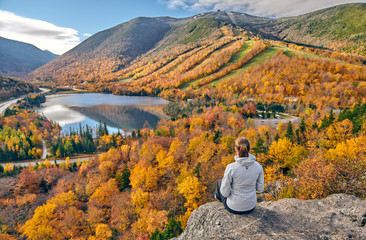 Wall Mural - Woman hiking at Artist's Bluff in autumn. View of Echo Lake. Fall colours in Franconia Notch State Park. White Mountain National Forest, New Hampshire, USA