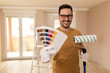 Young man painting apartment.