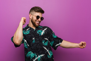 Wall Mural - Young man wearing a vacation look dancing and having fun.