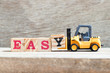 © bankrx - Toy forklift hold letter block y in word easy on wood background