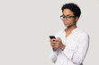 © fizkes - Serious biracial woman using cellphone browsing internet