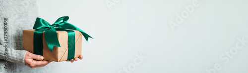 Fotomural Female hands hold gift box on white background, copy space right