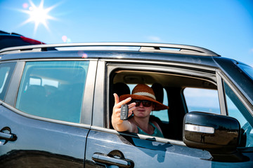 Poster - Black summer car and a girl on the beach. Happy smiling woman on the seashore view.