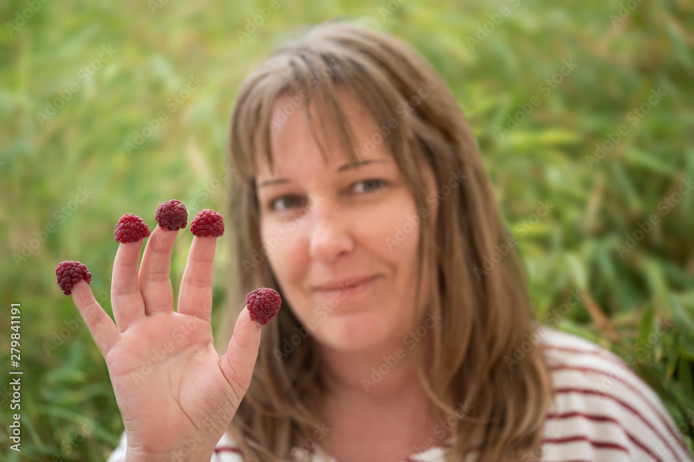 Friendly 40 year old woman shows her hand: on each finger is a plump ...