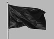 Black flag waving in the wind on flagpole, isolated on gray background, closeup