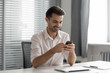 © fizkes - Happy businessman using smartphone corporate business apps in office