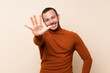 © luismolinero - Colombian man with turtleneck sweater counting five with fingers
