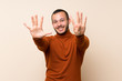 © luismolinero - Colombian man with turtleneck sweater counting nine with fingers