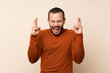 © luismolinero - Colombian man with turtleneck sweater with fingers crossing