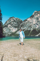 Wall Mural - man walking by lake beach mountains on background