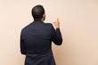© luismolinero - Colombian man over isolated background pointing back with the index finger