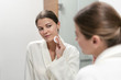 © brizmaker - Woman in white bathrobe holding cotton pad in hands