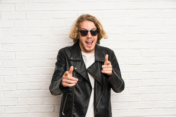 Blonde man with sunglasses points finger at you