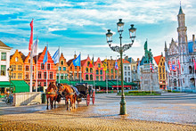 Horse Carriages On Grote Markt Square In Medieval City Brugge At Morning, Belgium.