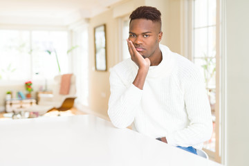 Poster - Handsome african american man on white table thinking looking tired and bored with depression problems with crossed arms.