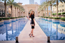 Beautiful Young Woman With Charming Smile And Long Hair Walking On Dubai Downtown.