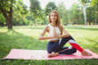 © Ihor - Beautiful red haired woman in sports clothing practicing yoga in the city park, copy space. Attractive fit woman doing yoga outdoors