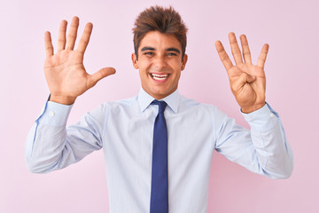 Young handsome businessman wearing shirt and tie standing over isolated pink background showing and pointing up with fingers number nine while smiling confident and happy.