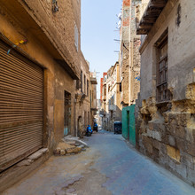Aged Houses With Crumbling Walls Located On Narrow Abandoned Street On Sunny Day In Old Cairo, Egypt
