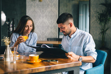 Wall Mural - A happy young couple looking at their menu's at a restaurant