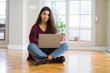 © Krakenimages.com - Young woman using computer laptop sitting on the floor skeptic and nervous, disapproving expression on face with crossed arms. Negative person.