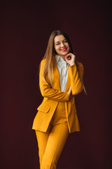 businesswoman posing in a stylish yellow suit against the backgr