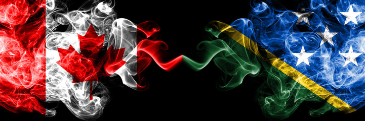 Canada vs Solomon Islands smoky mystic flags placed side by side. Thick colored silky smoke flags of Canadian and Solomon Islands.