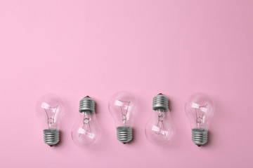 Wall Mural - New incandescent lamp bulbs on pink background, top view. Space for text