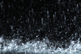 Fototapeta  - Heavy rain falling down on ground against dark background