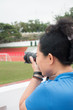 © Suttinun - The girl is using the camera to take pictures in the field.
