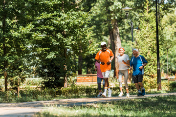 Wall Mural - selective focus multicultural senior men and women in sportswear jogging in park