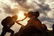 © kokliang1981 - Hiking team helping each other while climbing up in a sunset. The concept of aid.