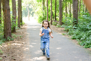 Wall Mural - Children, childhood and nature concept - Portrait of beautiful small baby girl playing in the park