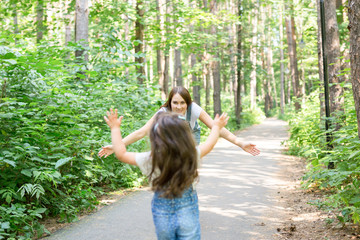 Family, parenthood and nature concept - Mother with daughter having fun in the green park