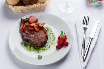 Wall Mural - beef stake with strawberry on white dish and basil saus