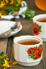 Wall Mural - A cup of hypericum tea on a wooden background 