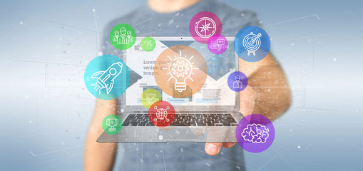Poster - businessman holding a cloud of colorfull start up icon bubble with a laptop 3d rendering