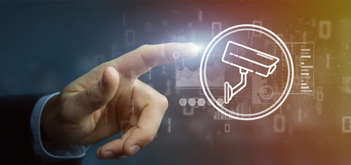 Poster - Businessman holding Security camera system icon and statistics data - 3d rendering