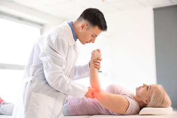 Sticker - Physiotherapist working with mature patient in rehabilitation center