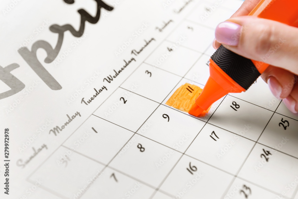 Woman marking date in calendar, closeup