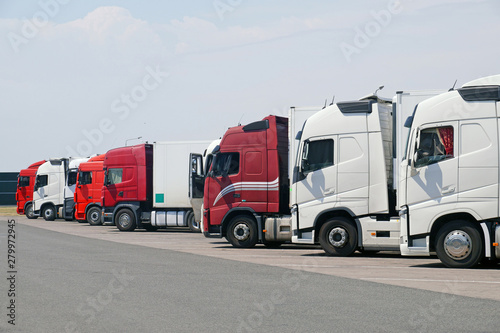 Fotomural Various types of trucks in the parking lot next to the motorway.