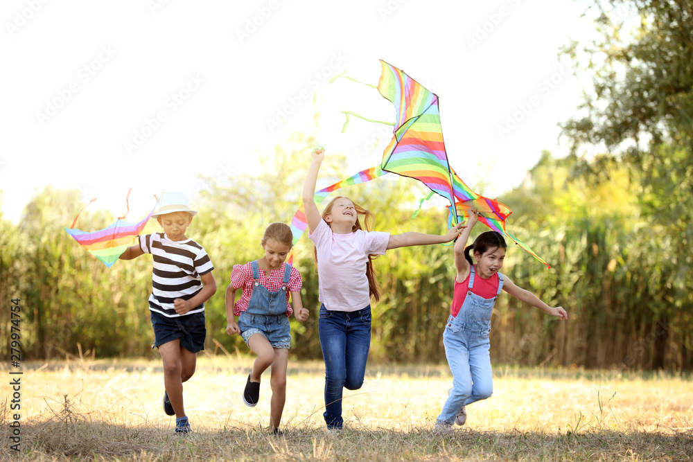 Little children flying kites outdoors