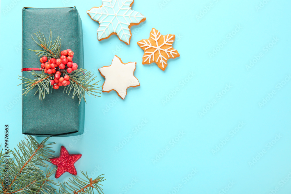Composition with beautiful Christmas gift box and cookies on color background