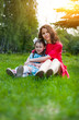 © Evgeny Leontiev - cute little girl and her mother having fun on the grass in a Sunny Park