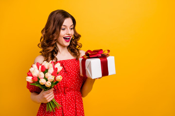 Poster - Beautiful foxy lady holding arms tulips bunch and big giftbox wear off-shoulders dress isolated yellow background