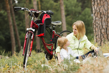 Wall Mural - Mother and daughter relaxing next to bike