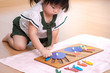 © myboys.me - An adorable asian preschool little girl (2-3 years) in Montessori classroom engaged sensory wooden puzzle activity. 10 fingers, Fine motor skills, Montessori method, Child development, Early education
